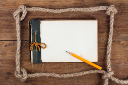 1943 year Antique Old Grunge Notepad in the Rope Frame on wooden background
